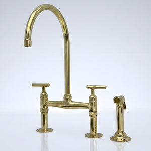 Unlacquered brass bridge kitchen faucet with side sprayer and Reed lever handles