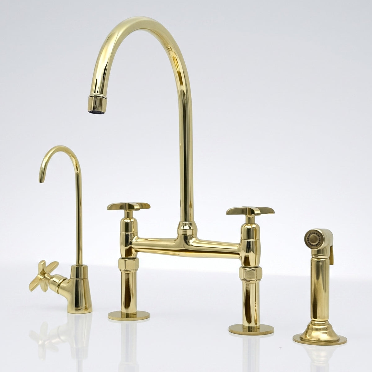 Close view of the unlacquered brass bridge kitchen faucet with cross handles and aged patina